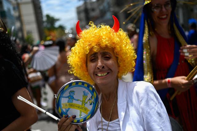 A reveler poses for a picture during a parade of the street carnival group Butano na Bureta in the streets of Maracana neighborhood, north zone of Rio de Janeiro, Brazil on February 7, 2026. The street carnival group pays tribute to Brazilian cinema past and present, with a special dedication to the recent worldwide hits ‘The Secret Agent’ and ‘I’m Still Here’. (Photo by Mauro PIMENTEL / AFP)