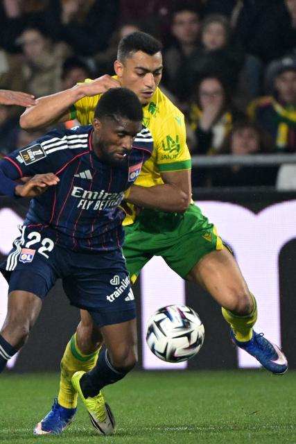 Nantes’ Egyptian forward #31 Mostafa Mohamed (R) fights for the ball with Lyon’s Angolan defender #22 Clinton Mata (C) during the French L1 football match between FC Nantes and Olympique Lyonnais (OL) at the Stade de la Beaujoire–Louis Fonteneau in Nantes, western France on February 7, 2026. (Photo by Damien Meyer / AFP)