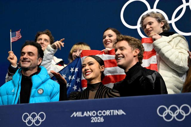 USA's Madison Chock (bottom row, 2L) and USA's Evan Bates (bottom row, R) react in the kiss and cry area after they competed in the figure skating team event ice dance-free dance during the Milano Cortina 2026 Winter Olympic Games at Milano Ice Skating Arena in Milan on February 7, 2026. (Photo by WANG Zhao / AFP)
