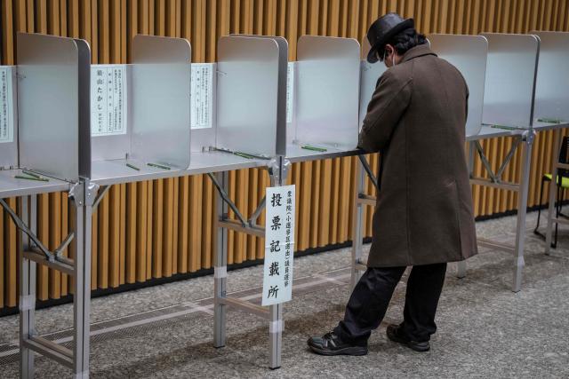 TOPSHOT - A voter takes part in the House of Representatives election at a polling station in Tokyo on February 8, 2026. Japan voted in snap elections February 8 with Prime Minister Sanae Takaichi hoping to turn a honeymoon start into a resounding ballot box victory that could rile China and rattle financial markets. (Photo by Yuichi YAMAZAKI / AFP)