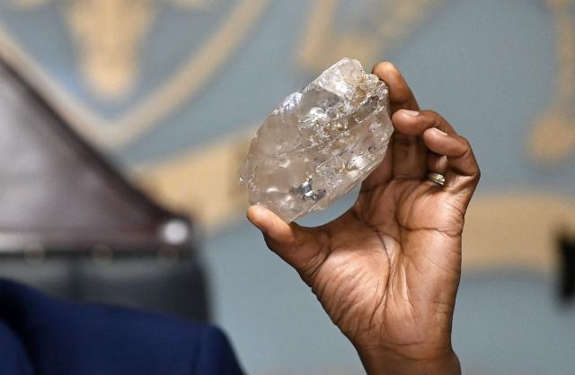 (FILES) Botswana's President Mokgweetsi Masisi holds a large diamond discovered in Botswana at his office in Gaborone on August 22, 2024. Even with its legendary image of glitz and glamour, diamond icon De Beers has struggled to attract a buyer after nearly three years on a market dulled by falling prices and the allure of lab-grown gems.
The seller -- mining titan Anglo American -- even warned Thursday it may take a third writedown in as many years on the company that was born in South Africa 130 years and went on to dominate the global diamond market. (Photo by Monirul BHUIYAN / AFP)