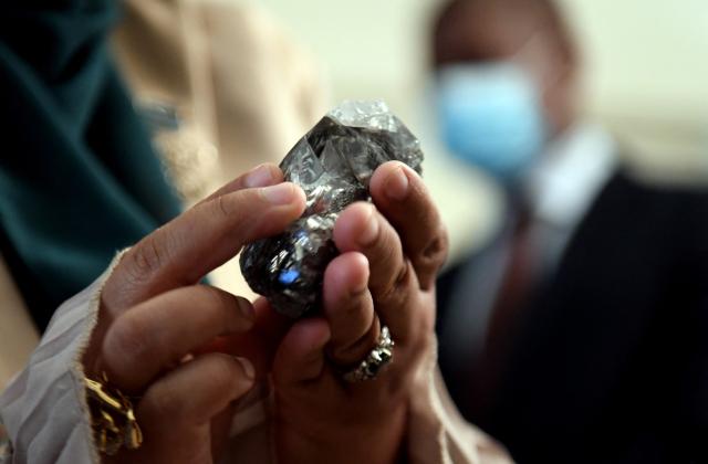 (FILES) A member of the Botswana cabinet holds a 1,174-carat diamond in Gaborone, Botswana, on July 7, 2021, that the Lucara Botswana found during an eleven day production run in June 2021. Even with its legendary image of glitz and glamour, diamond icon De Beers has struggled to attract a buyer after nearly three years on a market dulled by falling prices and the allure of lab-grown gems.
The seller -- mining titan Anglo American -- even warned Thursday it may take a third writedown in as many years on the company that was born in South Africa 130 years and went on to dominate the global diamond market. (Photo by Monirul Bhuiyan / AFP)