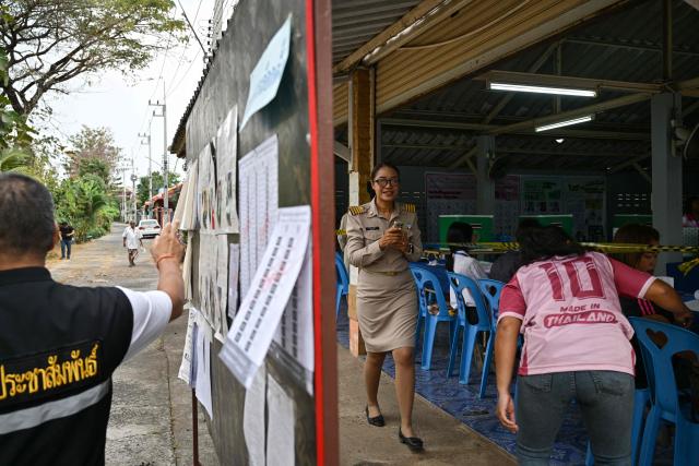 Officials wait for people to arrive for voting in Thailand's general election at a polling station in Buriram province on February 8, 2026. (Photo by ANTHONY WALLACE / AFP)