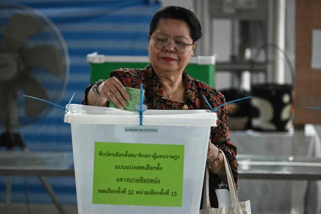 A voter casts her ballot in Thailand's general election at a polling station in Bangkok on February 8, 2026. (Photo by Lillian SUWANRUMPHA / AFP)