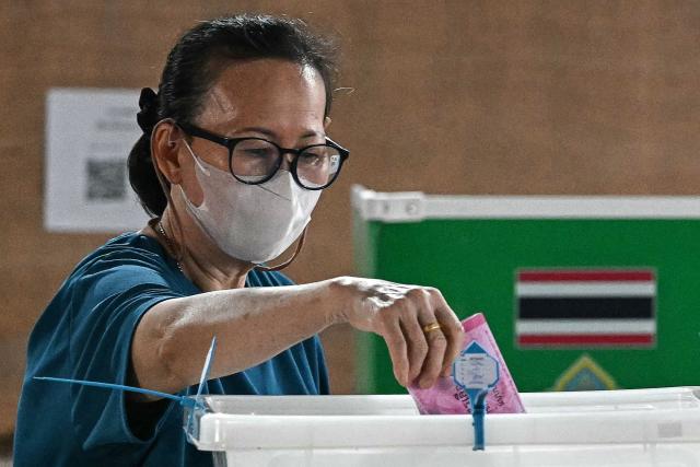A voter casts her ballot in Thailand's general election in Bangkok on February 8, 2026. Voting opened on February 8 in a Thai general election pitting the popular reformists who came first last time against the conservative who ended up as prime minister, with ex-leader Thaksin Shinawatra looming large from his prison cell. (Photo by Lillian SUWANRUMPHA / AFP)