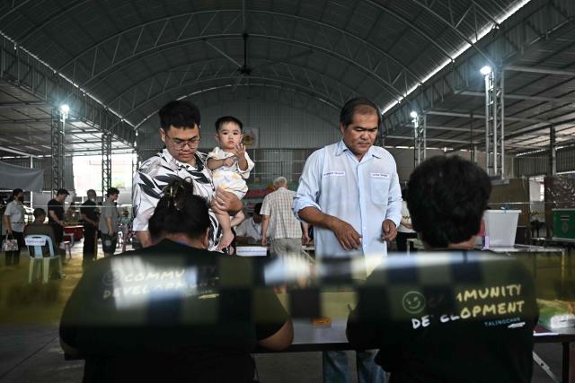 People register to vote in Thailand's general election in Bangkok on February 8, 2026. Voting opened on February 8 in a Thai general election pitting the popular reformists who came first last time against the conservative who ended up as prime minister, with ex-leader Thaksin Shinawatra looming large from his prison cell. (Photo by Lillian SUWANRUMPHA / AFP)