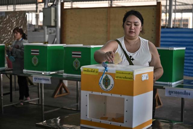 A voter casts her ballot in Thailand's general election in Bangkok on February 8, 2026. Voting opened on February 8 in a Thai general election pitting the popular reformists who came first last time against the conservative who ended up as prime minister, with ex-leader Thaksin Shinawatra looming large from his prison cell. (Photo by Lillian SUWANRUMPHA / AFP)