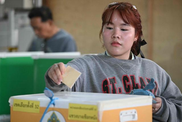 A voter casts her ballot in Thailand's general election in Bangkok on February 8, 2026. Voting opened on February 8 in a Thai general election pitting the popular reformists who came first last time against the conservative who ended up as prime minister, with ex-leader Thaksin Shinawatra looming large from his prison cell. (Photo by Lillian SUWANRUMPHA / AFP)