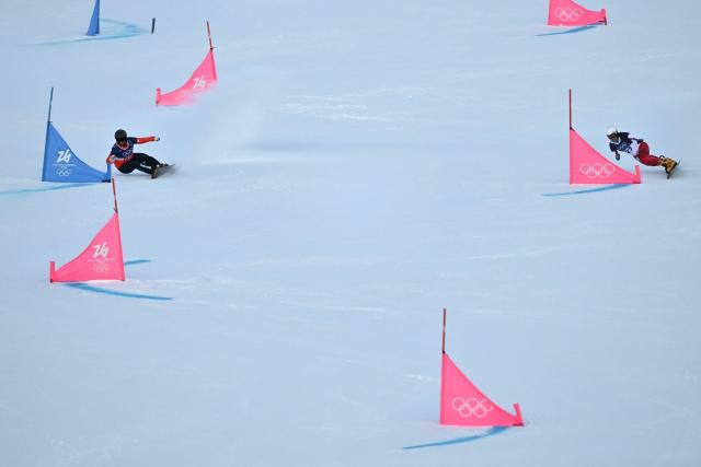 Poland's Aleksandra Krol-Walas (R) and Netherlands' Michelle Dekker (L) compete in the snowboard women's parallel giant slalom qualification run at Livigno Snow Park during the Milano Cortina 2026 Winter Olympic Games, in Livigno (Valtellina), on February 8, 2026. (Photo by Jeff PACHOUD / AFP)