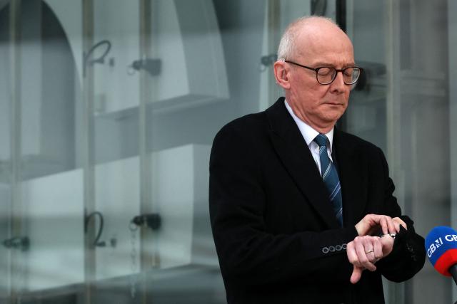 Britain's Pensions Secretary Pat McFadden checks his watch as he prepares to give an interview outside the BBC building in central London on February 8, 2026, after an appearance on the BBC's 'Sunday' political television show. (Photo by Adrian Dennis / AFP)