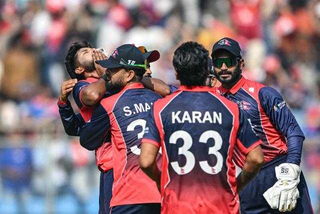 Nepal's Nandan Yadav (L) celebrates with teammates after taking the wicket of England's Jos Buttler during the 2026 ICC Men's T20 Cricket World Cup group stage match between England and Nepal at the Wankhede Stadium in Mumbai on February 8, 2026. (Photo by Indranil MUKHERJEE / AFP)
