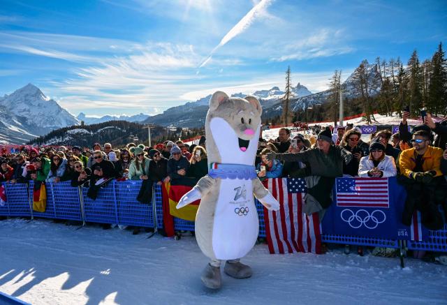 Olympic mascot Tina entertains spectators ahead of the women's downhill event during the Milano Cortina 2026 Winter Olympic Games at the Tofane Alpine Skiing Centre in Cortina d’Ampezzo on February 8, 2026. (Photo by Stefano RELLANDINI / AFP)