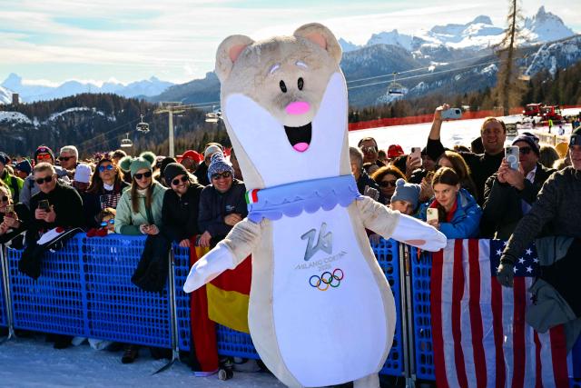 Olympic mascot Tina entertains spectators ahead of the women's downhill event during the Milano Cortina 2026 Winter Olympic Games at the Tofane Alpine Skiing Centre in Cortina d’Ampezzo on February 8, 2026. (Photo by Stefano RELLANDINI / AFP)