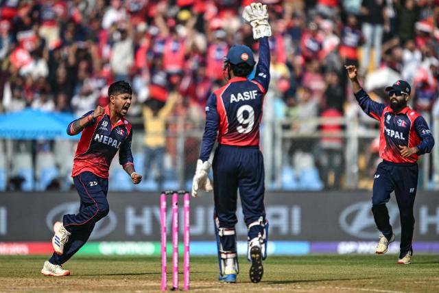 Nepal's Sandeep Lamichhane (L) celebrates with teammates after taking the wicket of England's Tom Banton during the 2026 ICC Men's T20 Cricket World Cup group stage match between England and Nepal at the Wankhede Stadium in Mumbai on February 8, 2026. (Photo by Indranil MUKHERJEE / AFP)