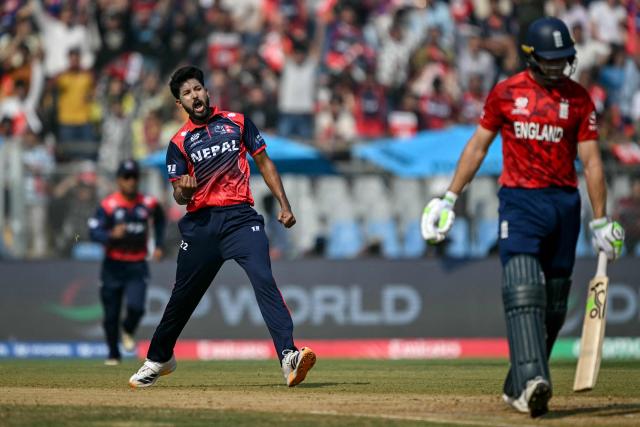 Nepal's Nandan Yadav (L) celebrates after taking the wicket of England's Jos Buttler during the 2026 ICC Men's T20 Cricket World Cup group stage match between England and Nepal at the Wankhede Stadium in Mumbai on February 8, 2026. (Photo by Indranil MUKHERJEE / AFP)