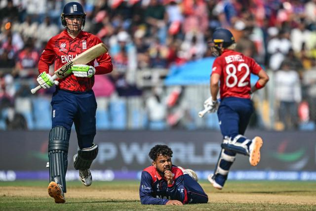 Nepal's Sher Malla (bottom) reacts after dropping a catch as England's Tom Banton (L) and Jacob Bethell run between the wickets during the 2026 ICC Men's T20 Cricket World Cup group stage match between England and Nepal at the Wankhede Stadium in Mumbai on February 8, 2026. (Photo by Indranil MUKHERJEE / AFP)