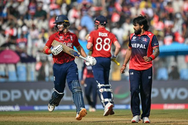 England's Jacob Bethell (L) and captain Harry Brook (C) run between the wickets as Nepal's Kushal Bhurtel watches during the 2026 ICC Men's T20 Cricket World Cup group stage match between England and Nepal at the Wankhede Stadium in Mumbai on February 8, 2026. (Photo by Indranil MUKHERJEE / AFP)