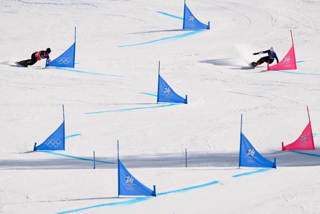Netherlands' Michelle Dekker (L) and Austria's Sabine Payer (R) compete in the snowboard women's parallel giant slalom last 16 run at Livigno Snow Park during the Milano Cortina 2026 Winter Olympic Games, in Livigno (Valtellina), on February 8, 2026. (Photo by Kirill KUDRYAVTSEV / AFP)