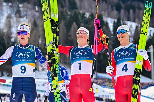Silver medallist France's Mathis Desloges (L), gold medallist Norway's Johannes Hoesflot Klaebo and bronze medallist Norway's Martin Loewstroem Nyenget celebrate at the end of the men's cross country 10km + 10km skiathlon event of the Milano Cortina 2026 Winter Olympic Games at Tesero Cross-Country Skiing Stadium in Lago di Tesero (Val di Fiemme), on February 8, 2026. (Photo by Tobias SCHWARZ / AFP)