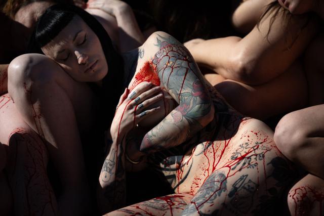 TOPSHOT - Activists of the animal rights group 'Anima Naturalis', naked and covered with fake blood, stage a protest against the use of leather and fur in Barcelona on February 8, 2026. (Photo by Josep LAGO / AFP)