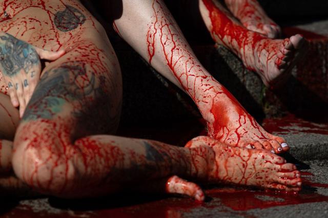Activists of the animal rights group 'Anima Naturalis', naked and covered with fake blood, stage a protest against the use of leather and fur in Barcelona on February 8, 2026. (Photo by Josep LAGO / AFP)