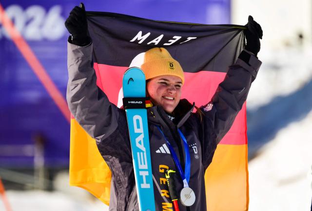 Germany's Emma Aicher holds up her silver medal on the podium of the women's downhill event during the Milano Cortina 2026 Winter Olympic Games at the Tofane Alpine Skiing Centre in Cortina d’Ampezzo on February 8, 2026. (Photo by Stefano RELLANDINI / AFP)