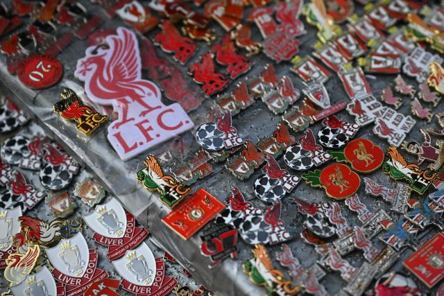 Club pins are offered for sale by a vendor outside the grounds before the start of the English Premier League football match between Liverpool and Manchester City at Anfield in Liverpool, north west England on February 8, 2026. (Photo by Paul ELLIS / AFP)