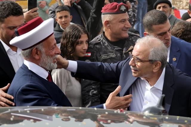 Judicial Muslim Mufti of the southern Lebanese towns of Marjayoun and Hasbaya Hassan Dali (L) greets Lebanon's Prime Minister Nawaf Salam during his visit to the heavily-damaged southern village of Kfar Shouba, near the border with Israel on February 8, 2026. Swathes of south Lebanon's border areas remain in ruins and largely deserted more than a year after a US-brokered November 2024 ceasefire sought to end hostilities between Israel and the Iran-backed group. Salam vowed authorities would begin key projects including restoring roads, communications networks and water in the two towns (Photo by Rabih DAHER / AFP)