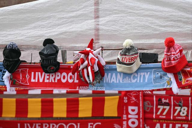 Hats are offered for sale by a vendor outside the grounds before the start of the English Premier League football match between Liverpool and Manchester City at Anfield in Liverpool, north west England on February 8, 2026. (Photo by Paul ELLIS / AFP)