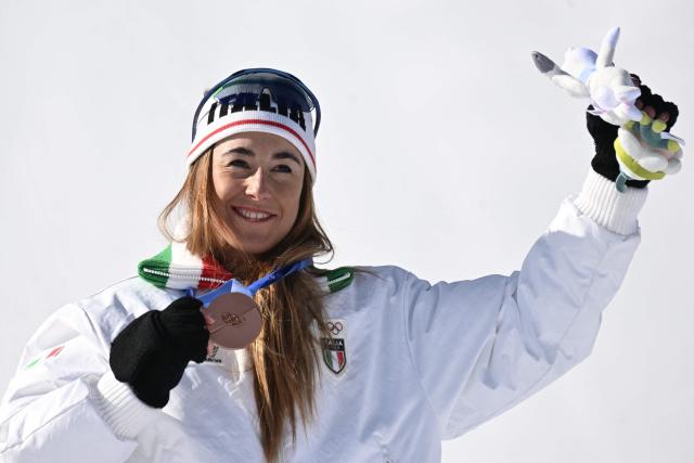 Bronze medallist Italy's Sofia Goggia pose on the podium of the women's downhill event during the Milano Cortina 2026 Winter Olympic Games at the Tofane Alpine Skiing Centre in Cortina d’Ampezzo on February 8, 2026. (Photo by Tiziana FABI / AFP)