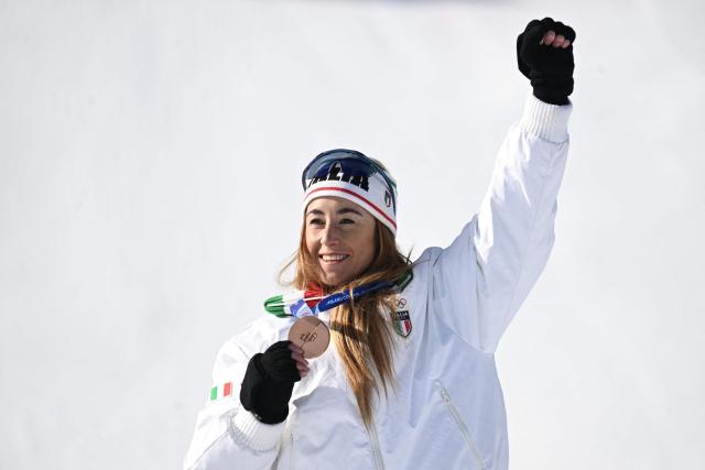 Bronze medallist Italy's Sofia Goggia pose on the podium of the women's downhill event during the Milano Cortina 2026 Winter Olympic Games at the Tofane Alpine Skiing Centre in Cortina d’Ampezzo on February 8, 2026. (Photo by Tiziana FABI / AFP)