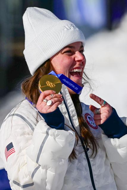 US' Breezy Johnson holds up her gold medal on the podium of the women's downhill event during the Milano Cortina 2026 Winter Olympic Games at the Tofane Alpine Skiing Centre in Cortina d’Ampezzo on February 8, 2026. (Photo by Stefano RELLANDINI / AFP)