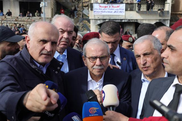 Former Lebanese finance minister, current member of parliament and a high ranking member of the Shiite Muslim Amal movement Ali Hasan Khalil (L), points as he stands next to Lebanon's Prime Minister Nawaf Salam during his visit to the heavily-damaged southern village of Kfar Shouba, near the border with Israel on February 8, 2026. Swathes of south Lebanon's border areas remain in ruins and largely deserted more than a year after a US-brokered November 2024 ceasefire sought to end hostilities between Israel and the Iran-backed group. Salam vowed authorities would begin key projects including restoring roads, communications networks and water in the two towns (Photo by Rabih DAHER / AFP)