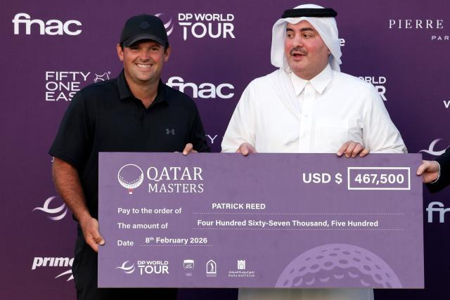 US' Patrick Reed (L) celebrates on the podium with his winnings after winning the Qatar Masters 2026 golf tournament at Doha Golf Club in Doha on February 8, 2026. (Photo by Karim JAAFAR / AFP)