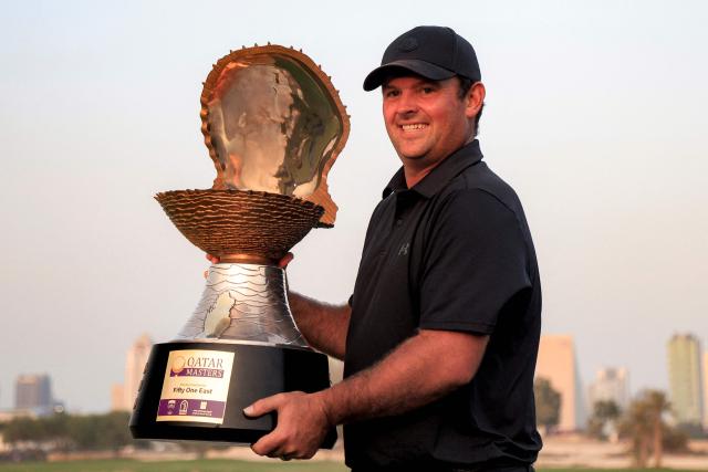 US' Patrick Reed celebrates with the trophy after winning the Qatar Masters 2026 golf tournament at Doha Golf Club in Doha on February 8, 2026. (Photo by Karim JAAFAR / AFP)