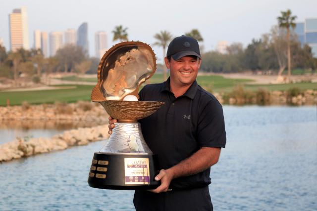US' Patrick Reed celebrates with the trophy after winning the Qatar Masters 2026 golf tournament at Doha Golf Club in Doha on February 8, 2026. (Photo by Karim JAAFAR / AFP)