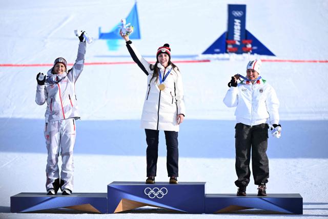 (From L) Silver medallist Austria's Sabine Payer, gold medallist Czech Republic's Zuzana Maderova and bronze-medallist Italy's Lucia Dalmasso celebrate on the podium after the snowboard women's parallel giant slalom final at Livigno Snow Park during the Milano Cortina 2026 Winter Olympic Games, in Livigno (Valtellina), on February 8, 2026. (Photo by Kirill KUDRYAVTSEV / AFP)