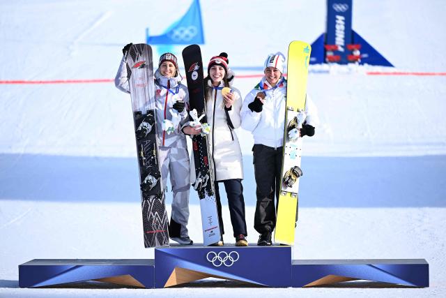 (From L) Silver medallist Austria's Sabine Payer, gold medallist Czech Republic's Zuzana Maderova and bronze-medallist Italy's Lucia Dalmasso celebrate on the podium after the snowboard women's parallel giant slalom final at Livigno Snow Park during the Milano Cortina 2026 Winter Olympic Games, in Livigno (Valtellina), on February 8, 2026. (Photo by Kirill KUDRYAVTSEV / AFP)