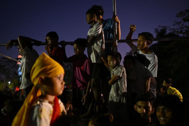 People watch as Hindu devotees take part in a religious procession during the firewalk festival in Yangon on February 8, 2026. (Photo by Sai Aung MAIN / AFP)