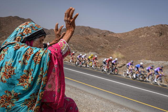 An elderly woman gestures as the pack rides during the 2nd stage of the Tour of Oman cycling race from Al Rustaq Fort to Yitti Hills on February 8, 2026. (Photo by Loic VENANCE / AFP)