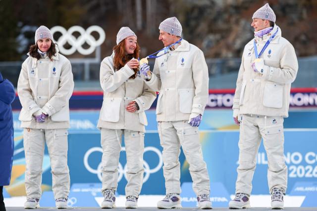 Gold medallists France's Eric Perrot, France's Quentin Fillon Maillet, France's Lou Jeanmonnot, France's Julia Simon celebrate on the podium of the mixed biathlon 4 x 6km relay event during the Milano Cortina 2026 Winter Olympic Games at the Anterselva Biathlon Arena (Sudtirol Arena) in Anterselva (Val Pusteria) on February 8, 2026. (Photo by FRANCK FIFE / AFP)