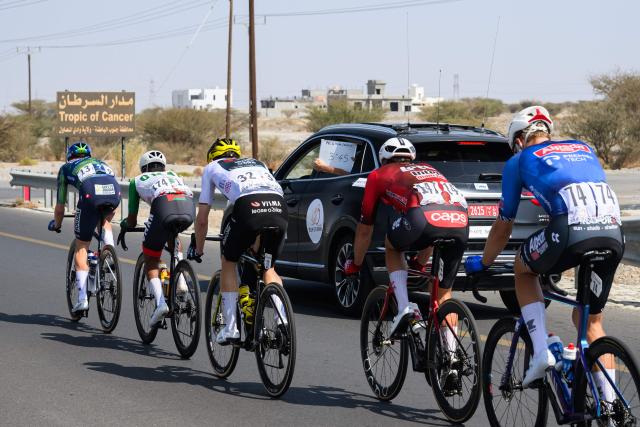 A referee shows the break away the time from the pack as they cross the Tropic of Cancer line during the 2nd stage of the Tour of Oman cycling race from Al Rustaq Fort to Yitti Hills, on February 8, 2026. (Photo by Loic VENANCE / AFP)