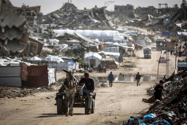 A man drives donkey-drawn cart past the rubble of destroyed buildings in the Jabalia camp for Palestinian refugees in the northern Gaza Strip on February 8, 2026. Since October 10, a fragile US-sponsored truce in Gaza has largely halted the fighting between Israeli forces and Hamas, but both sides have alleged frequent violations. (Photo by Omar AL-QATTAA / AFP)