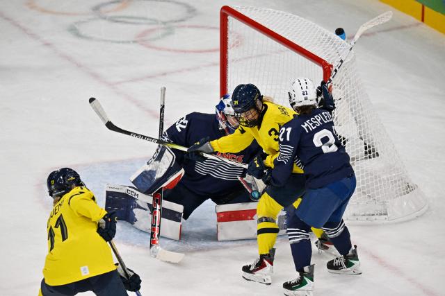 France's #21 Julia Mesplede (R) and France's #32 Alice Philbert vie with Sweden's #34 Mira Hallin during the women's preliminary round Group B Ice Hockey match between France and Sweden at the Milano Rho Ice Hockey Arena at the Milano Cortina 2026 Winter Olympic Games in Milan, on February 8, 2026. (Photo by Alexander NEMENOV / AFP)