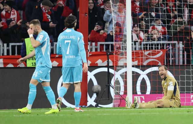 Hoffenheim's German goalkeeper #01 Oliver Baumann (R) reacts after failing to save a penalty during the German first division Bundesliga football match between FC Bayern Munich and TSG 1899 Hoffenheim in Munich, southern Germany on February 8, 2026. (Photo by Alexandra BEIER / AFP) / DFL REGULATIONS PROHIBIT ANY USE OF PHOTOGRAPHS AS IMAGE SEQUENCES AND/OR QUASI-VIDEO