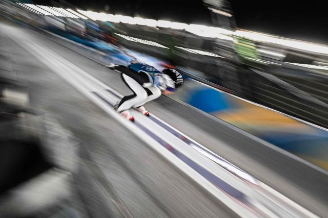 Romania's Daniel Andrei Cacina goes down the inrun during the men's ski jumping normal hill training of the Milano Cortina 2026 Winter Olympic Games at Predazzo Ski Jumping Stadium in Predazzo (Val di Fiemme), on February 8, 2026. (Photo by Javier SORIANO / AFP)