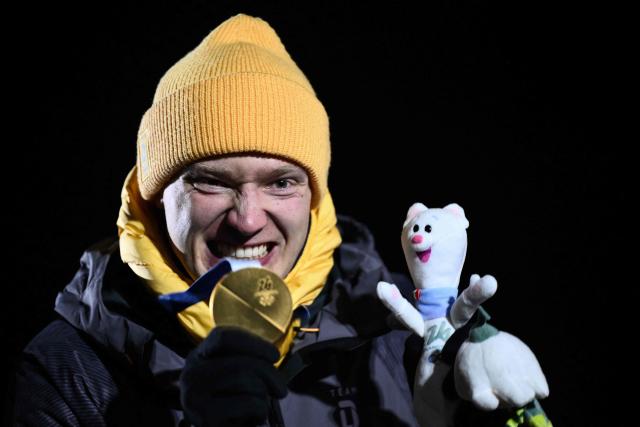 Gold medallist Germany's Max Langenhan reacts on the podium of the luge men's singles at Cortina Sliding Centre during the Milano Cortina 2026 Winter Olympic Games in Cortina d'Ampezzo on February 8, 2026. (Photo by Marco BERTORELLO / AFP)