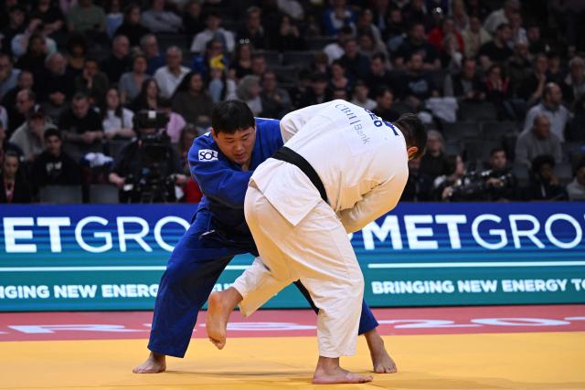 South Korea's Minjong Kim (in blue) competes against Gerogia's Irakli Demetrashvili in the men's +100kg Bronze bout at the Paris Grand Slam judo tournament in Paris on February 8, 2026. (Photo by Julie SEBADELHA / AFP)