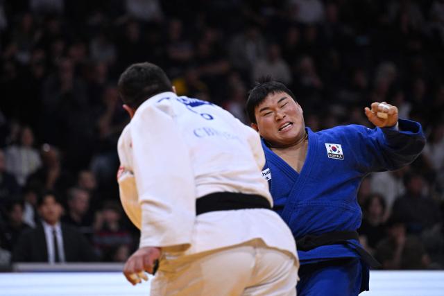South Korea's Minjong Kim (in blue) competes against Gerogia's Irakli Demetrashvili in the men's +100kg Bronze bout at the Paris Grand Slam judo tournament in Paris on February 8, 2026. (Photo by Julie SEBADELHA / AFP)