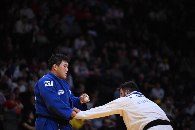 South Korea's Minjong Kim (in blue) competes against Gerogia's Irakli Demetrashvili in the men's +100kg Bronze bout at the Paris Grand Slam judo tournament in Paris on February 8, 2026. (Photo by Julie SEBADELHA / AFP)